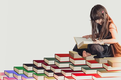 Girl Sitting on Stack of books